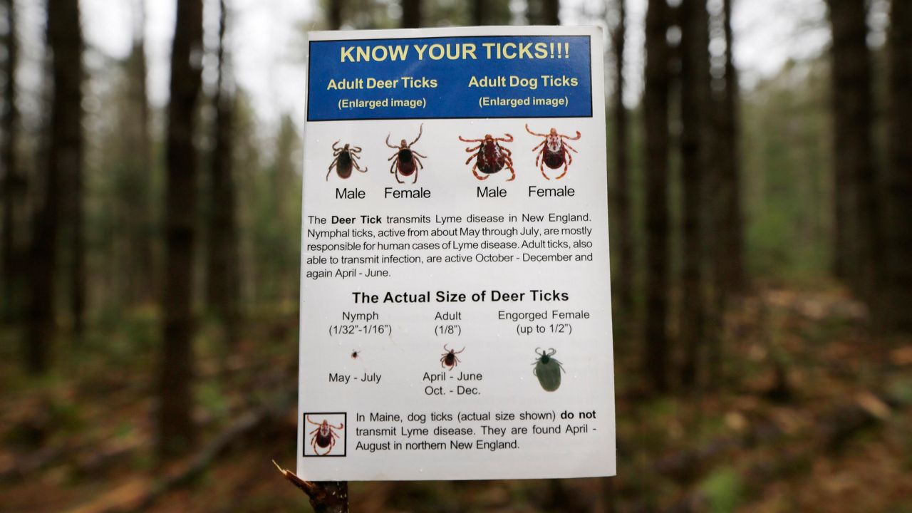A warning sign about tick-borne illness on a trail