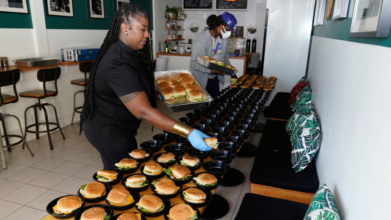 Kyndra McCrary, owner of Ooh La La Catering, prepares a catered lunch for a client at her restaurant, Swift Cafe, Tuesday, Feb. 8, 2022, in Los Angeles. (AP Photo/Marcio Jose Sanchez)