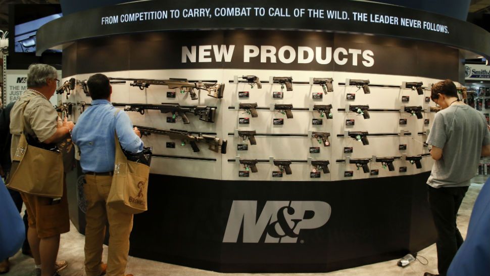 Attendees at the National Rifle Association convention view a display of weapons on display on the convention floor in Dallas, Friday, May 4, 2018. (AP Photo/Sue Ogrocki)