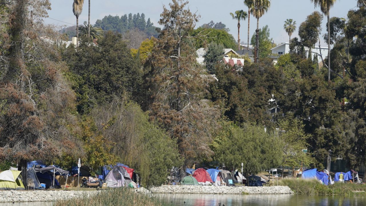 A homeless encampment remains around the west perimeter of Echo Park Lake Friday, March 26, 2021. (AP Photo/Damian Dovarganes)