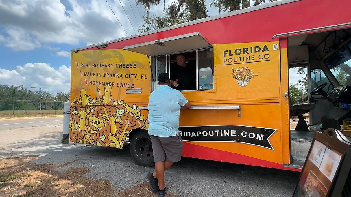Eric Primeau inside his food truck, serving a customer. (Spectrum News/Julia Hazel)