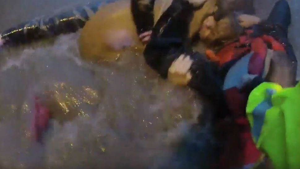 Screenshot of the moment APD Officer Benjamin Cochran grabs onto Officer Matthew Valli, a woman and a dog during a water rescue Friday, May 3. (Photo Courtesy: Austin Police Department)