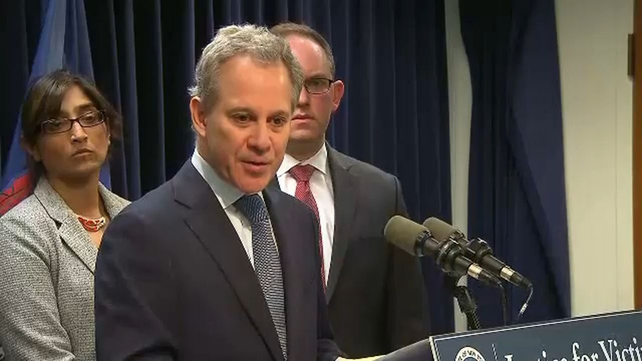 Eric Schneiderman wearing a black suit jacket, a white dress shirt, and a grey tie.