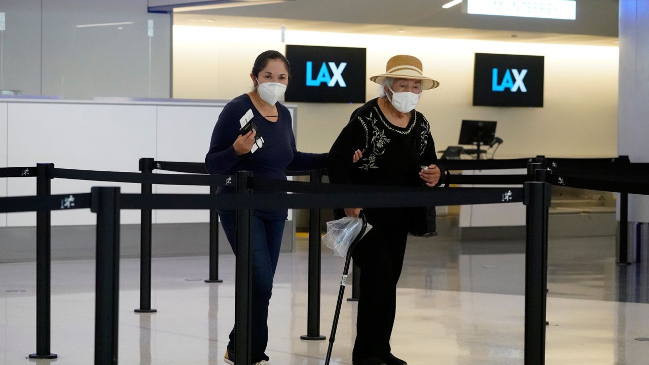 Travelers wear masks at a ticket counter at Los Angeles International Airport Monday, April 25, 2022, in Los Angeles. (AP Photo/Marcio Jose Sanchez)