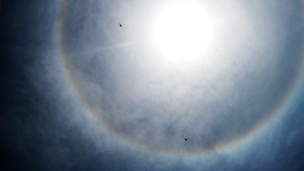 Jets from the U.S. Navy's Blue Angels, flying near MacDill Air Force Base in Tampa, pass in front of a striking sun halo seen across Florida on Thursday.