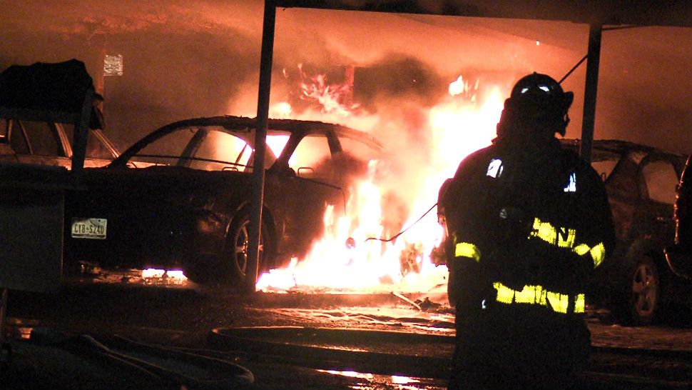 A firefighter works to put out a fire that damaged 10 vehicles. (Image/Ken Braca)