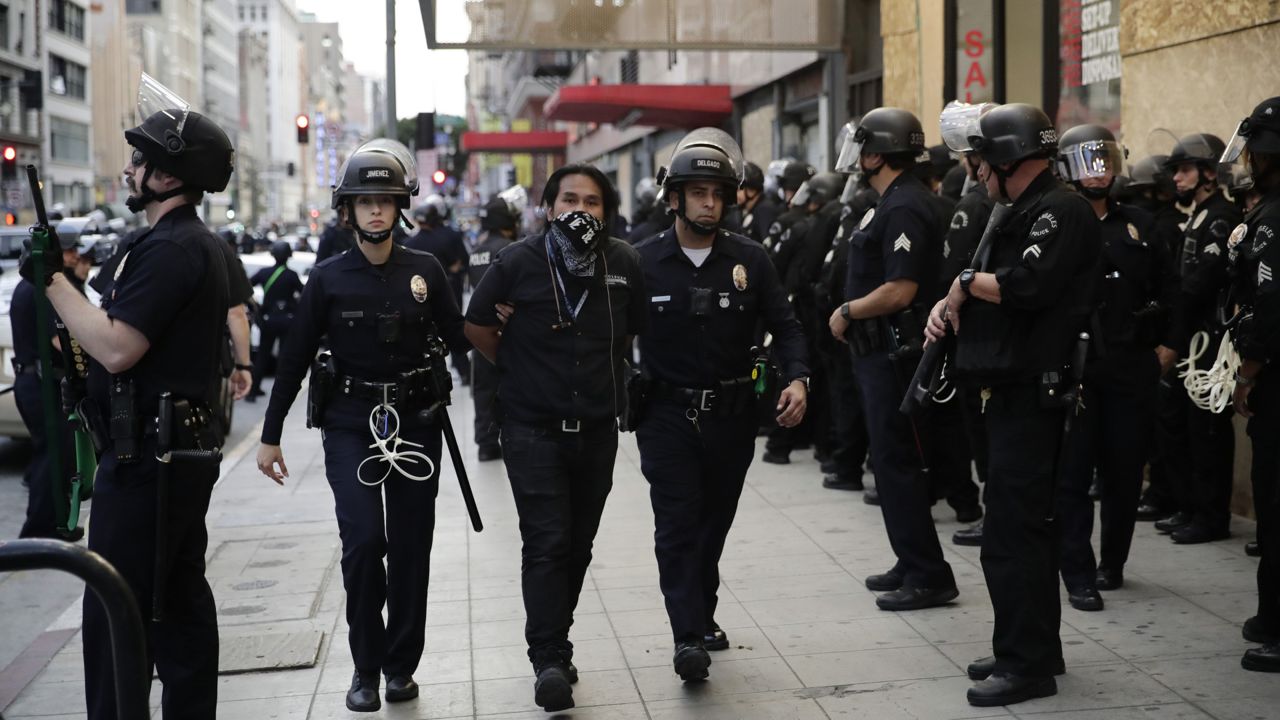 A demonstrator is taken into custody after the city's curfew went into effect Tuesday, June 2, 2020, in Los Angeles during protests nationwide over the death of George Floyd on May 25 while in police custody in Minneapolis. (AP Photo/Jae C. Hong)
