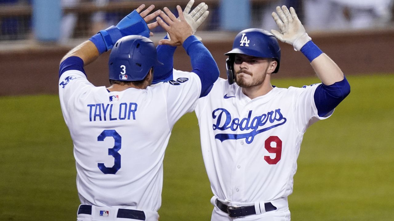 Los Angeles Dodgers' Gavin Lux, right, is congratulated by Chris Taylor after hitting a three-run home run during the eighth inning of an interleague baseball game against the Seattle Mariners Tuesday, May 11, 2021, in Los Angeles. (AP Photo/Mark J. Terrill)