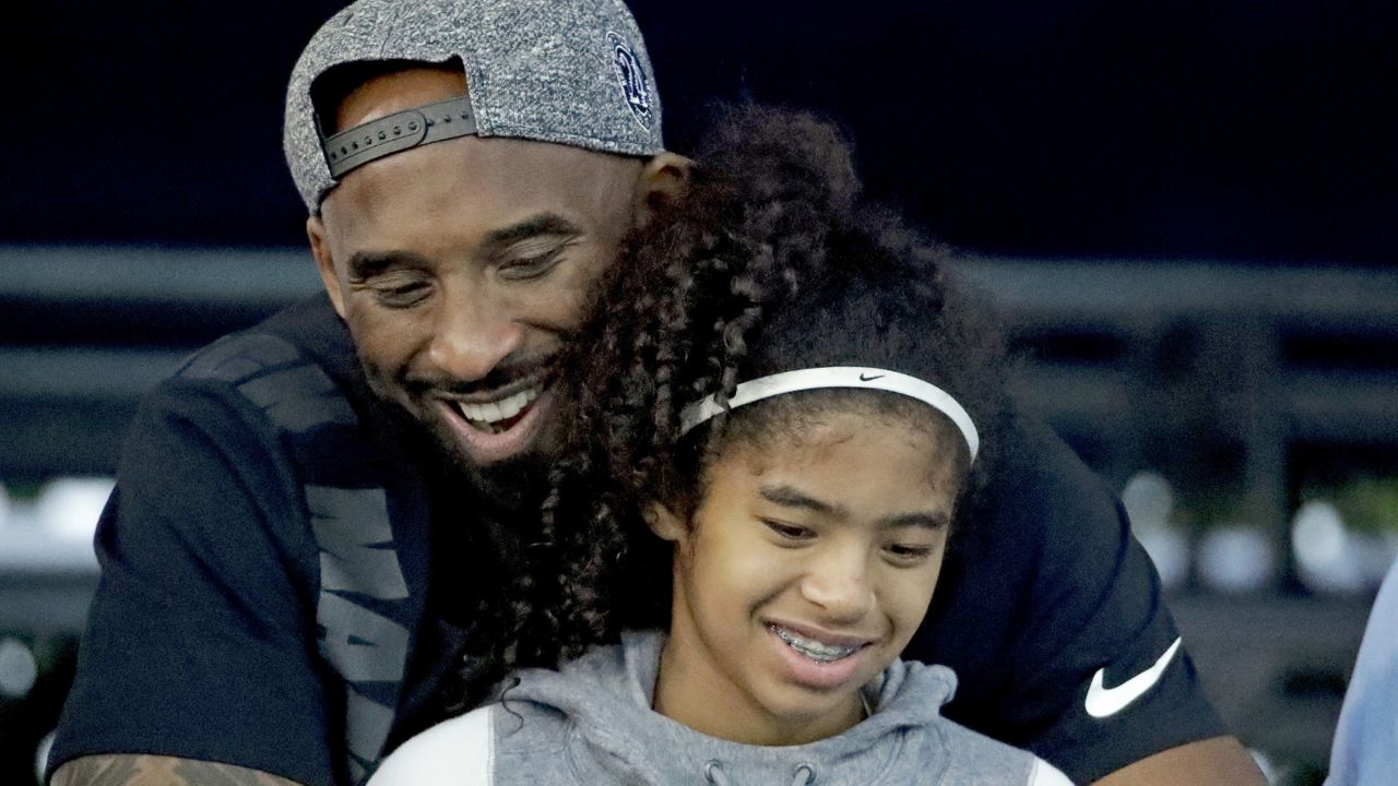 Former Los Angeles Laker Kobe Bryant and his daughter Gianna watch the U.S. national championships swimming meet in Irvine, Calif. on July 26, 2018. (AP Photo/Chris Carlson)