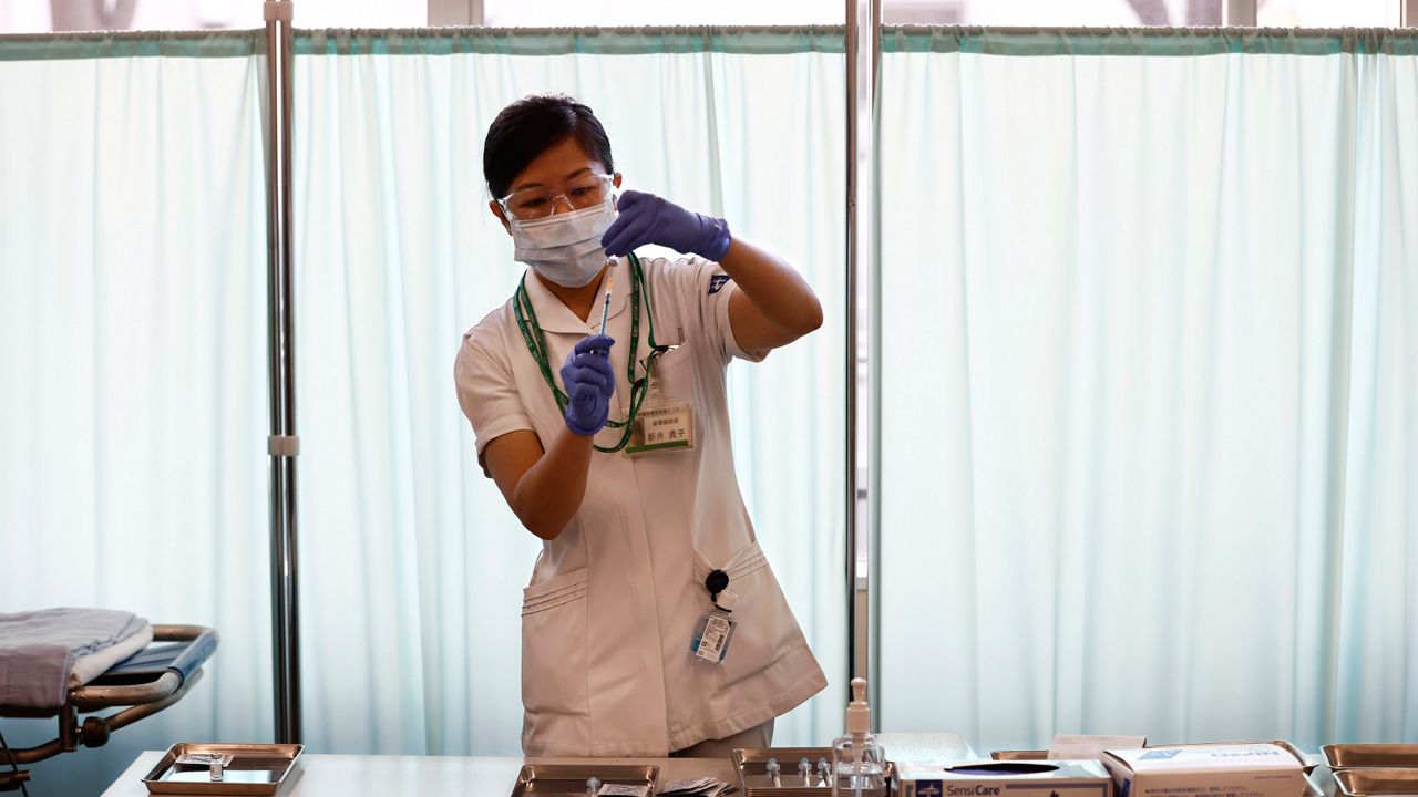 A medical worker fills a syringe with Pfizer's COVID-19 vaccine