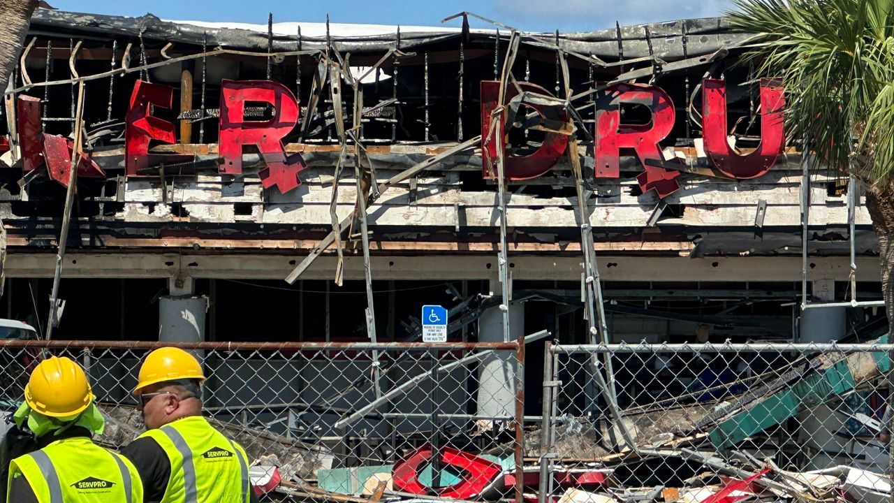 Crews continued Wednesday to work at Dolphin Village Plaza in St. Pete Beach after flames tore through the buildings on Tuesday. (Spectrum News/Melissa Eichman)