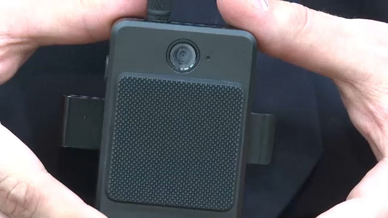 A person holds a body camera.