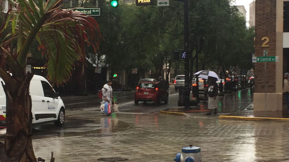 People try to stay dry as they go about their day in Downtown Orlando. (Spectrum News file)