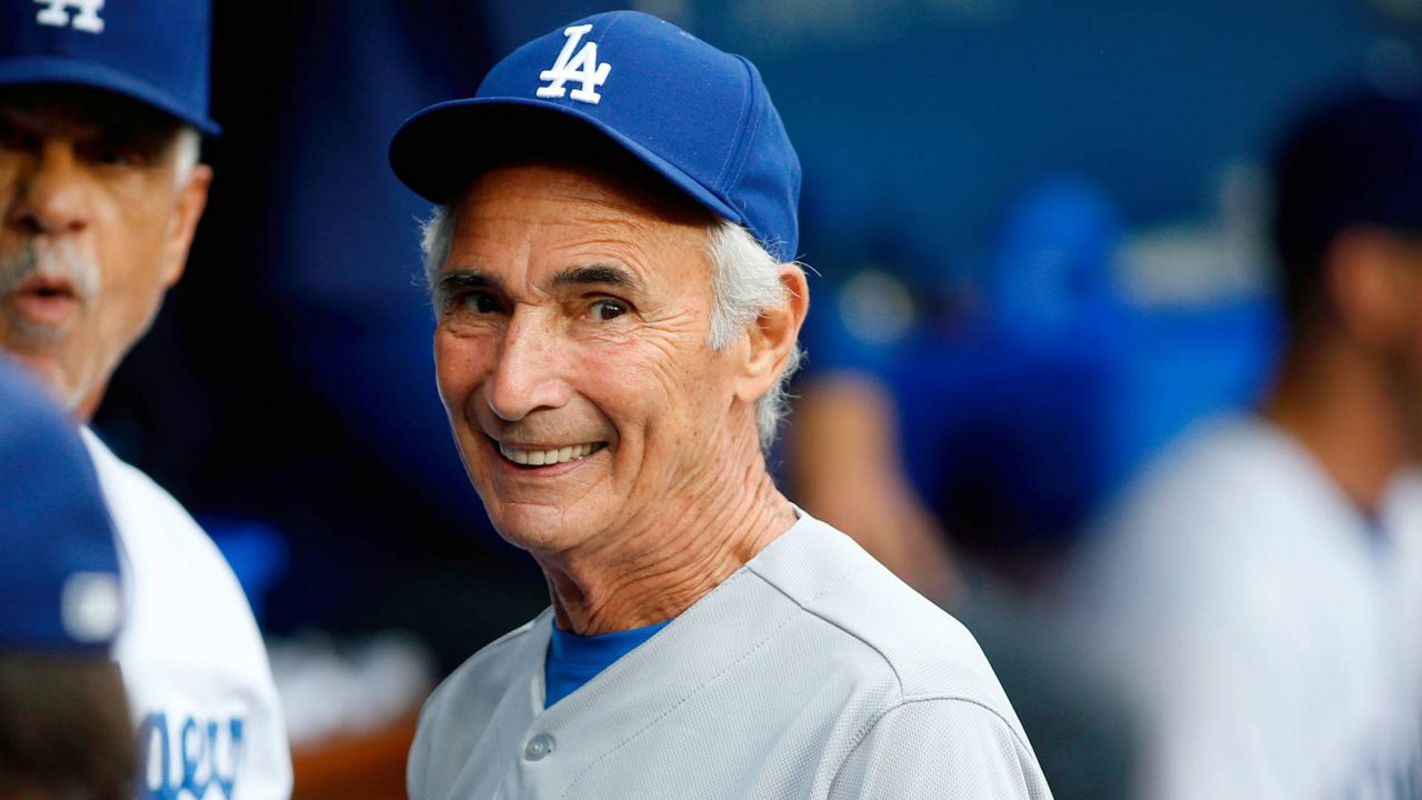 Los Angeles Dodgers Hall of Fame pitcher Sandy Koufax, on hand for the Dodgers' Old Timers Game festivities, smiles as he talks to current members of the team in the dugout before a game, May 16, 2015, in LA. (AP Photo/Danny Moloshok, File)