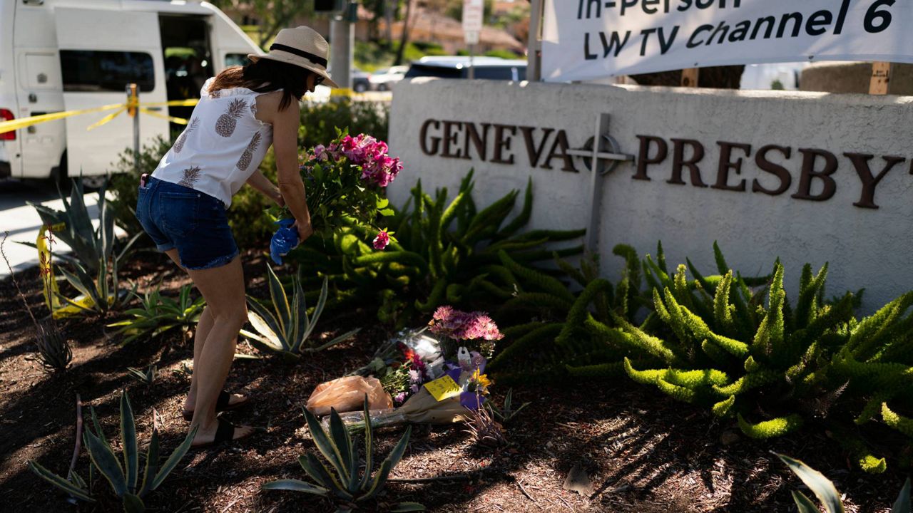 Joanna Garcia, 47, leaves flowers outside Geneva Presbyterian Church to honor victims in Sunday's shooting at the church in Laguna Woods, Calif., on May 16, 2022. (AP Photo/Jae C. Hong)