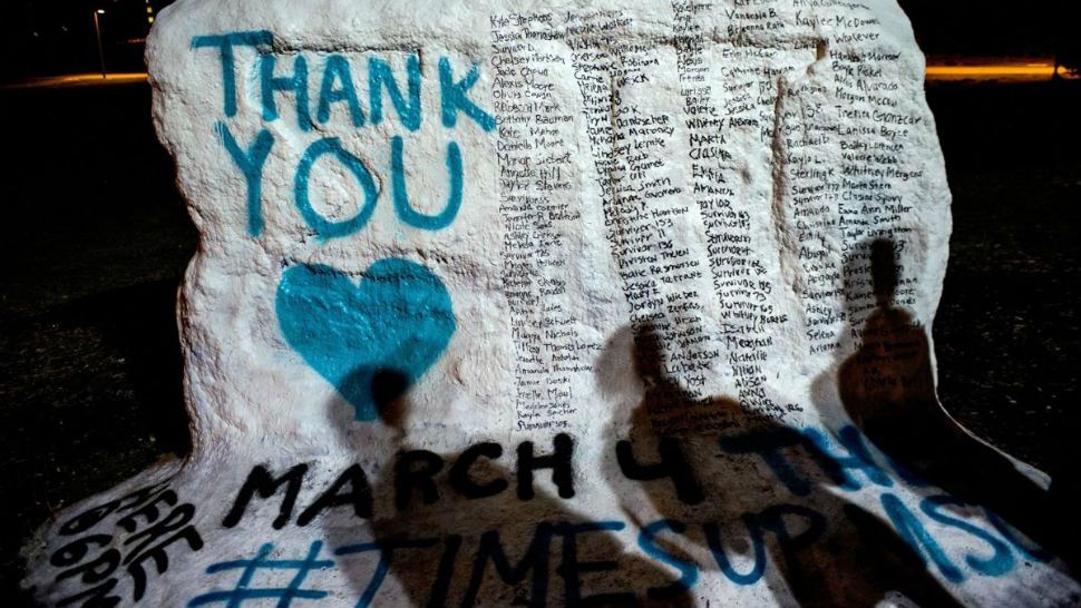 FILE - In this Jan. 26, 2018, file photo, the shadows of Michigan State University students appear on “the rock” in the university campus which was painted “Thank You” and includes the names of the women who gave victim impact statements during the Larry Nassar sexual assault sentencing hearing in East Lansing, Mich. Michigan State University announced Wednesday, May 16, 2018, that it has reached a $500 million settlement with hundreds of women and girls who say they were sexually assaulted by sports Nassar in the worst sex-abuse case in sports history. (Jake May/The Flint Journal-MLive.com via AP, File)