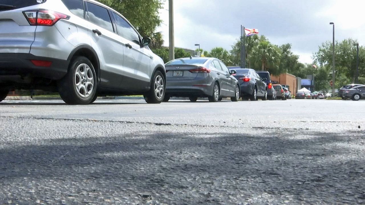 Cars wrapped around the block waiting in line outside Engelwood Neighborhood Center to obtain face coverings Saturday during a community mask giveaway. (Matt Fernandez/Spectrum News 13)