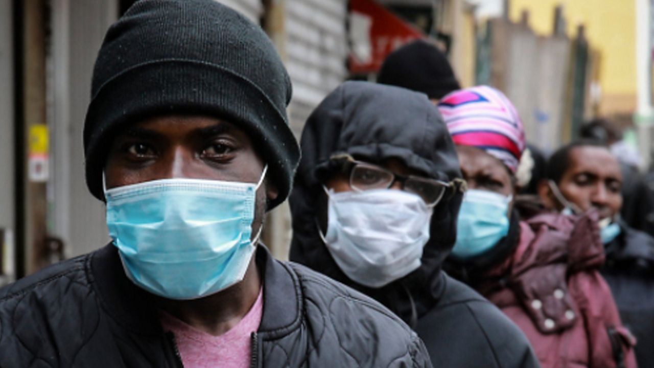 African Americans in a line wearing face masks