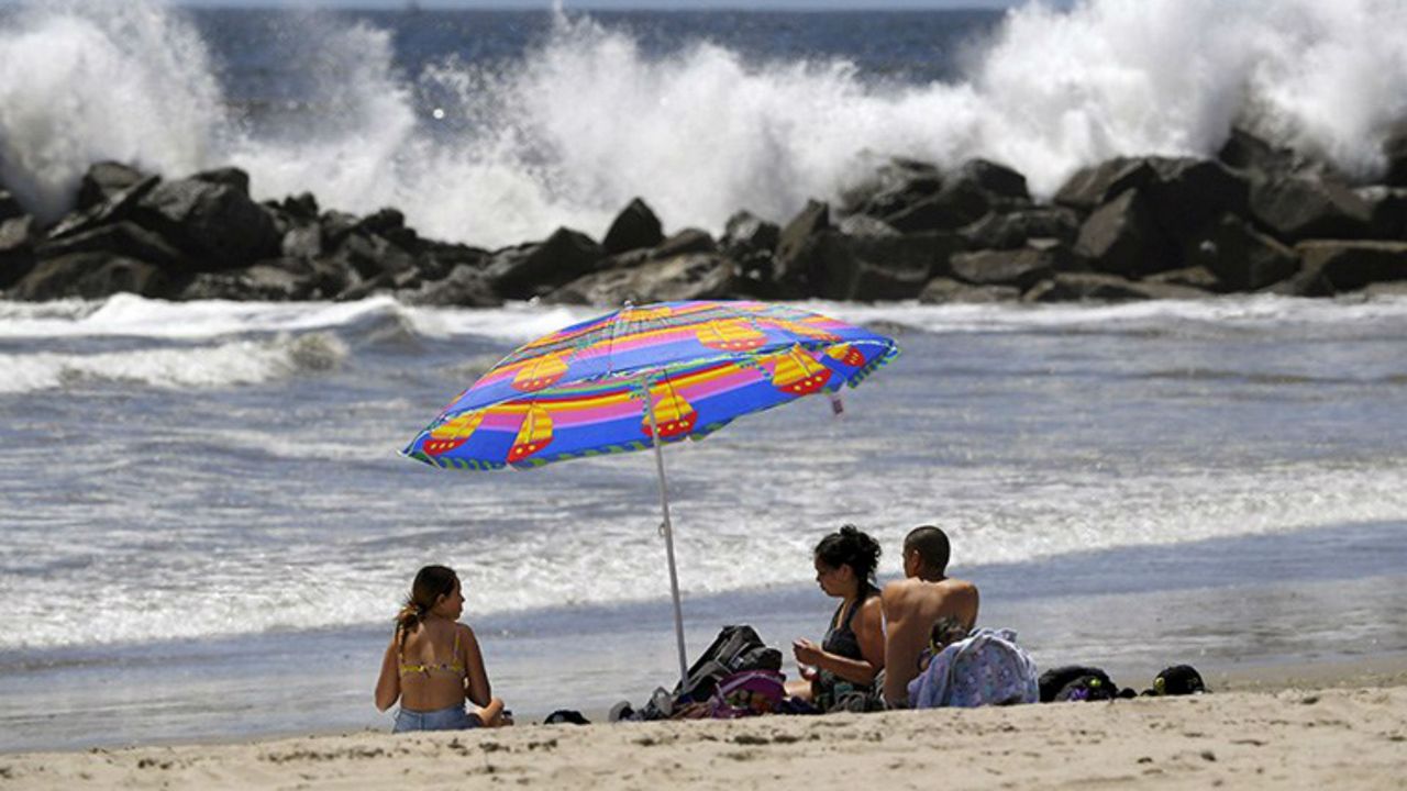 Beachgoers sit on Venice Beach during the coronavirus outbreak, Wednesday, May 13, 2020, in Los Angeles. Los Angeles County reopened its beaches Wednesday in the latest cautious easing of coronavirus restrictions that have closed most California public spaces and businesses for nearly two months. (AP Photo/Mark J. Terrill)