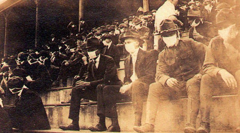 This undated photo provided by Georgia Tech alumnus Andy McNeil shows a Georgia Tech home game during the 1918 college football season. The photo was taken by Georgia Tech student Thomas Carter, who would receive a degree in Mechanical Engineering. The 102-year-old photo could provide a snapshot of sports once live games resume: Fans packed in a campus stadium in the midst of a pandemic wearing masks with a smidge of social distance between them on concrete seats. (Thomas Carter via AP)