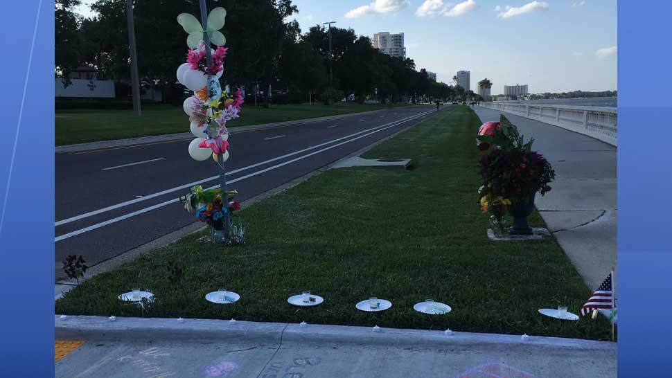 A makeshift memorial composed of flowers, candles, and chalk drawings on the sidewalk in honor of Jessica Raubenolt, 24, and her daughter, Lilia, 21 months, who were killed after they were struck at that location on Bayshore Boulevard one year ago. (Laurie Davison/Spectrum Bay News 9)