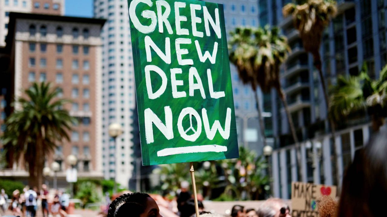 Climate change activists holding signs join in on a rally supporting the "Green New Deal" in Pershing Square in downtown Los Angeles on May 24, 2019. (AP Photo/Richard Vogel)