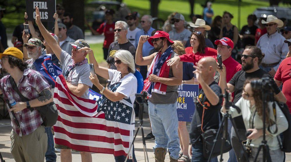 The Texas Freedom Rally protesters demonstrate against additional restrictions due to the coronavirus pandemic on the south steps of the state Capitol on Saturday, May 23, 2020, in Austin, Texas. As more sectors of the Texas economy reopened from the freeze of the coronavirus pandemic, a few dozen anti-government demonstrators rallied Saturday at the state Capitol to demand that all limitations be lifted. (Ricardo B. Brazziell/Austin American-Statesman via AP)