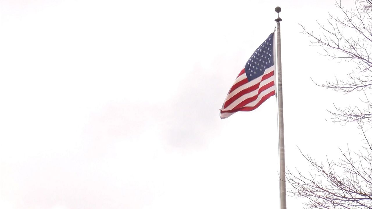 An American flag blows in the wind outside David Prouty High School in Spencer. 