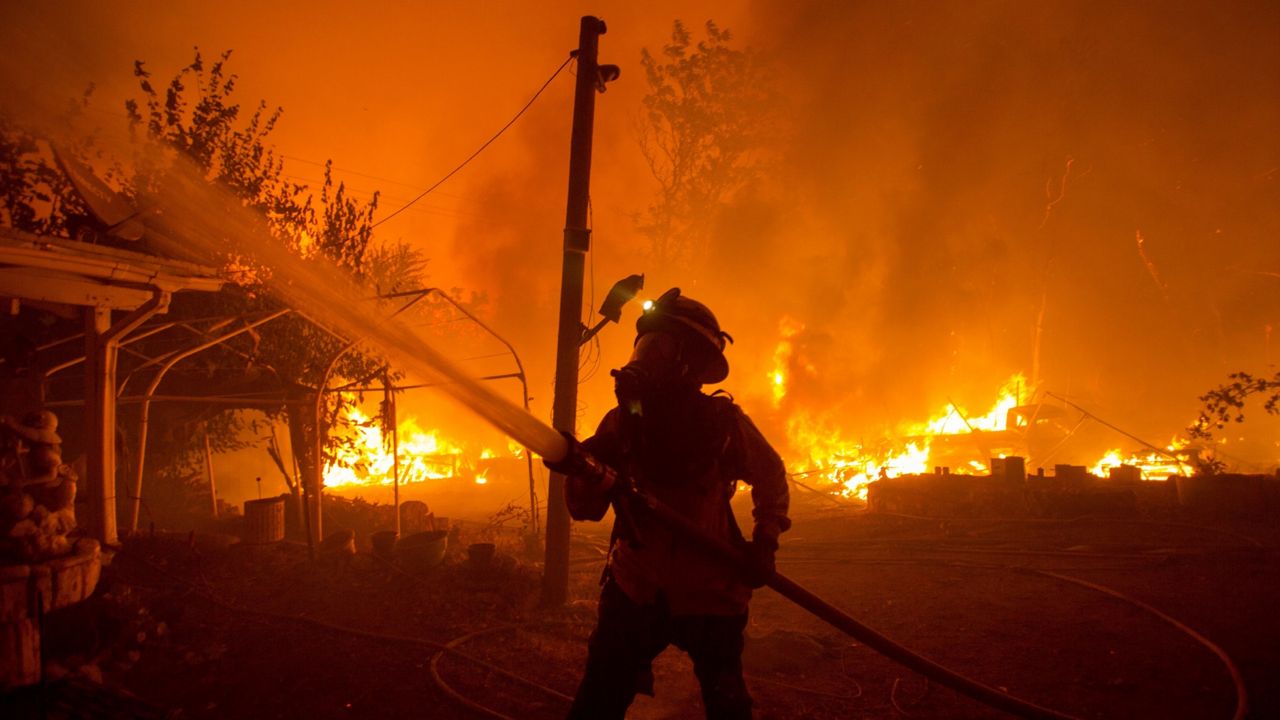 A firefighter works against the Lake Hughes Fire in Angeles National Forest north of Santa Clarita, Calif. on Aug. 12, 2020. (AP Photo/Ringo H.W. Chiu)