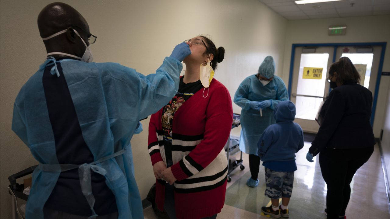 School employee Amanda Anguiano gets tested for COVID-19 on the first day of in-person learning at Maurice Sendak Elementary School in Los Angeles on April 13, 2021. (AP Photo/Jae C. Hong)