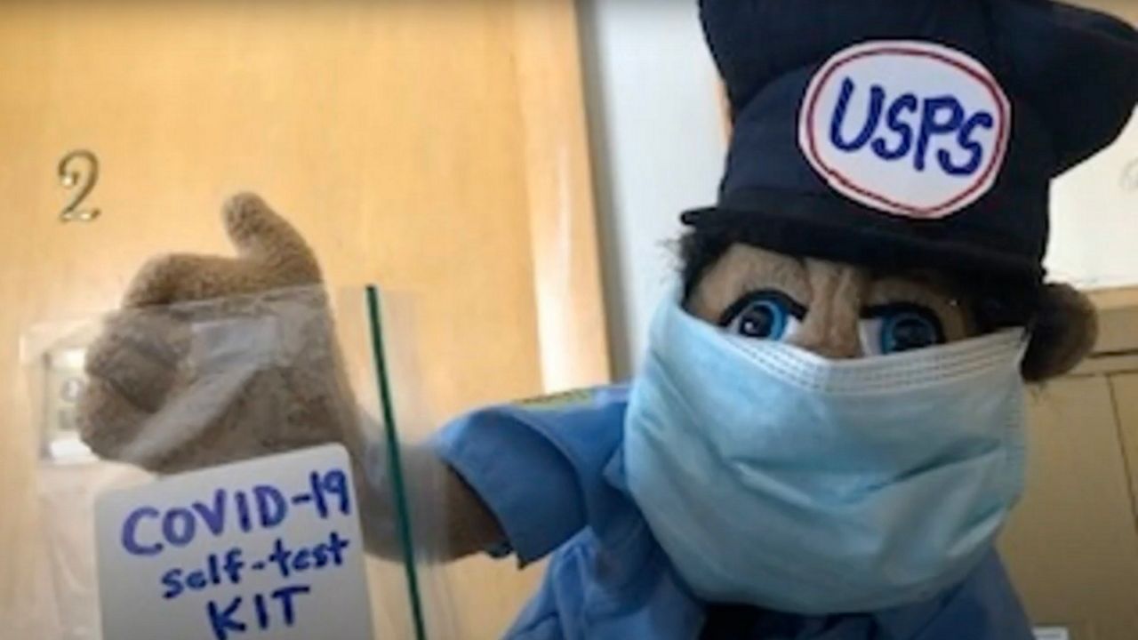 A screenshot from a student video shows a puppet postal worker delivering a COVID-19 test