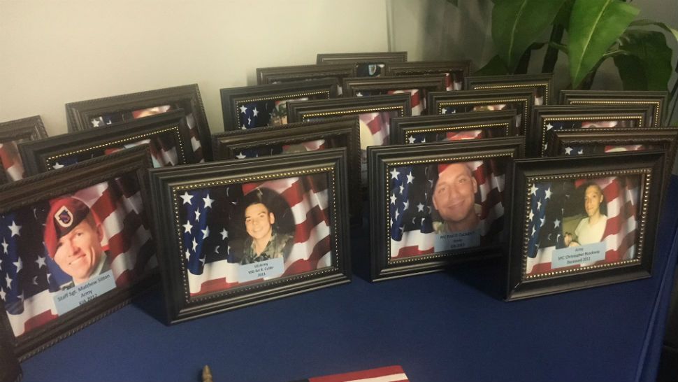 Pictures of service members who were killed in combat were displayed during a remembrance ceremony in Tampa on Sunday. (Stephanie Claytor, staff)