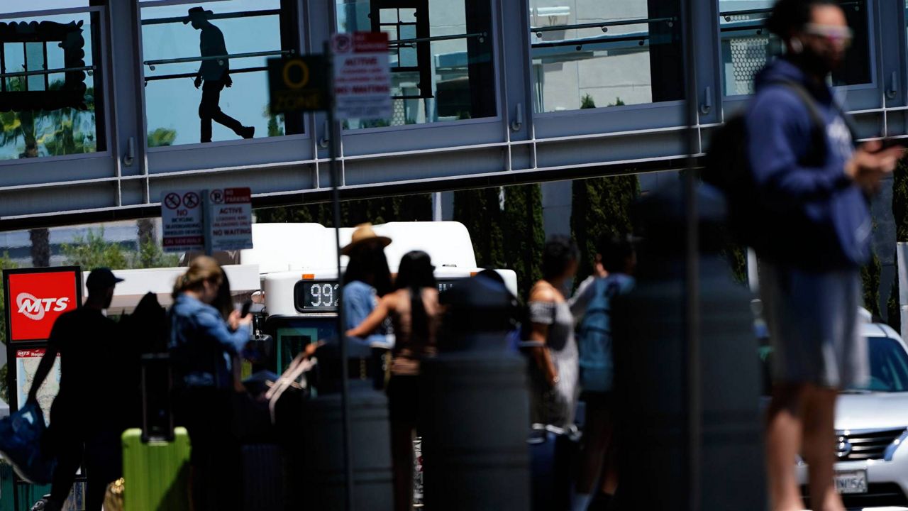 People arrive and depart from the airport ahead of Memorial Day weekend, May 28, 2021, in San Diego. (AP Photo/Gregory Bull)