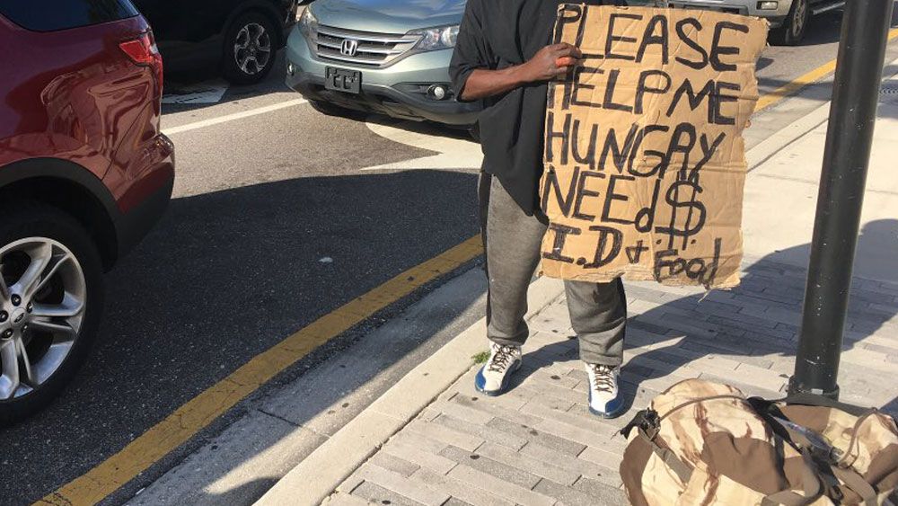 A panhandler holds up a sign in Downtown Orlando. A new Downtown Ambassador Program will help provide information to tourists 24/7, and even help with panhandlers. (Erin Murray, Staff)