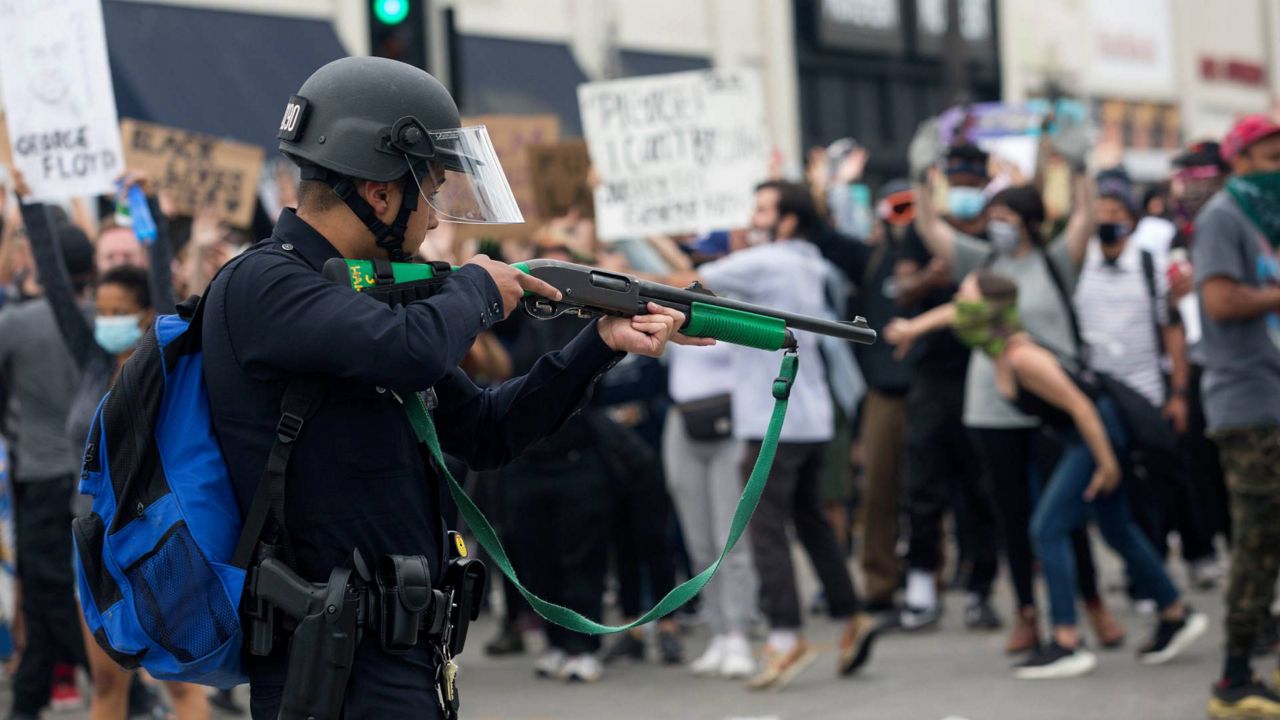 A police officer prepares to fire rubber bullets during a protest over the death of George Floyd in Los Angeles, May 30, 2020. (AP Photo/Ringo H.W. Chiu, File)