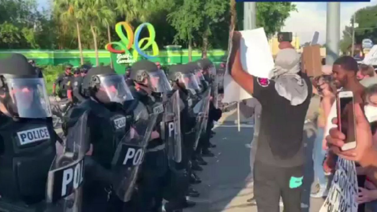 Tampa police stand in front of protesters near Busch Gardens on Saturday. (Josh Fiallo/Tampa Bay Times)
