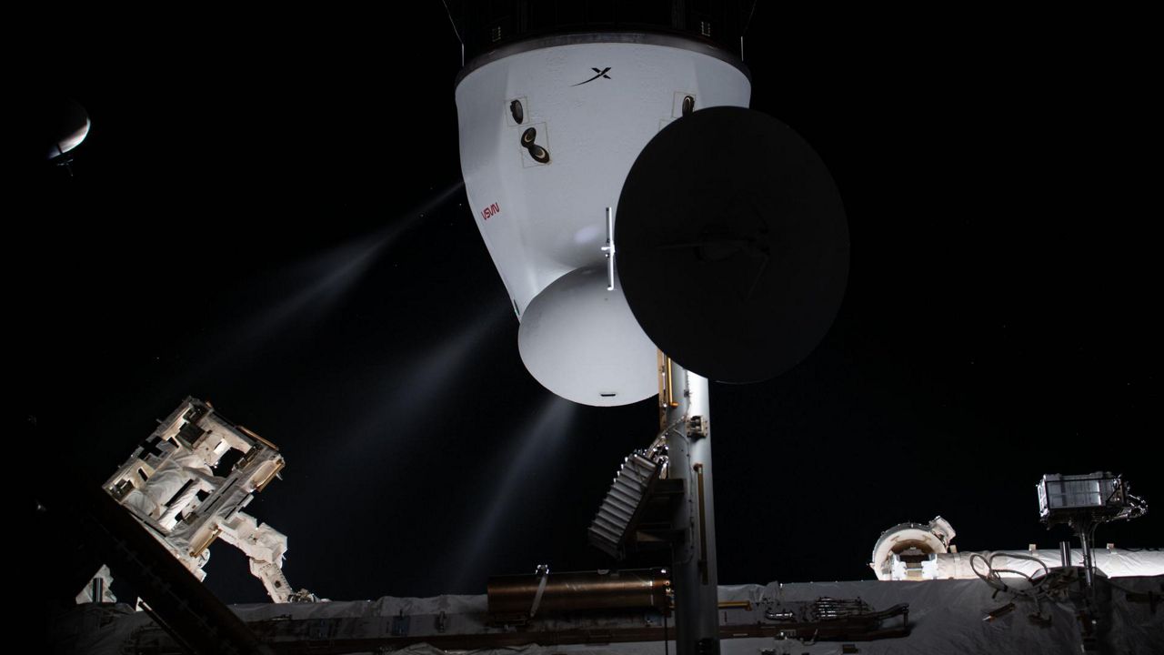 In this file photo provided by NASA, white plumes are seen coming out of SpaceX’s Dragon spacecraft’s Draco engines. During a recent pre-launch test, when propellant was being loaded into the Dragon, elevated vapor readings were detected and the CRS-25 mission was postponed so engineers could run inspections for the cause. (NASA)