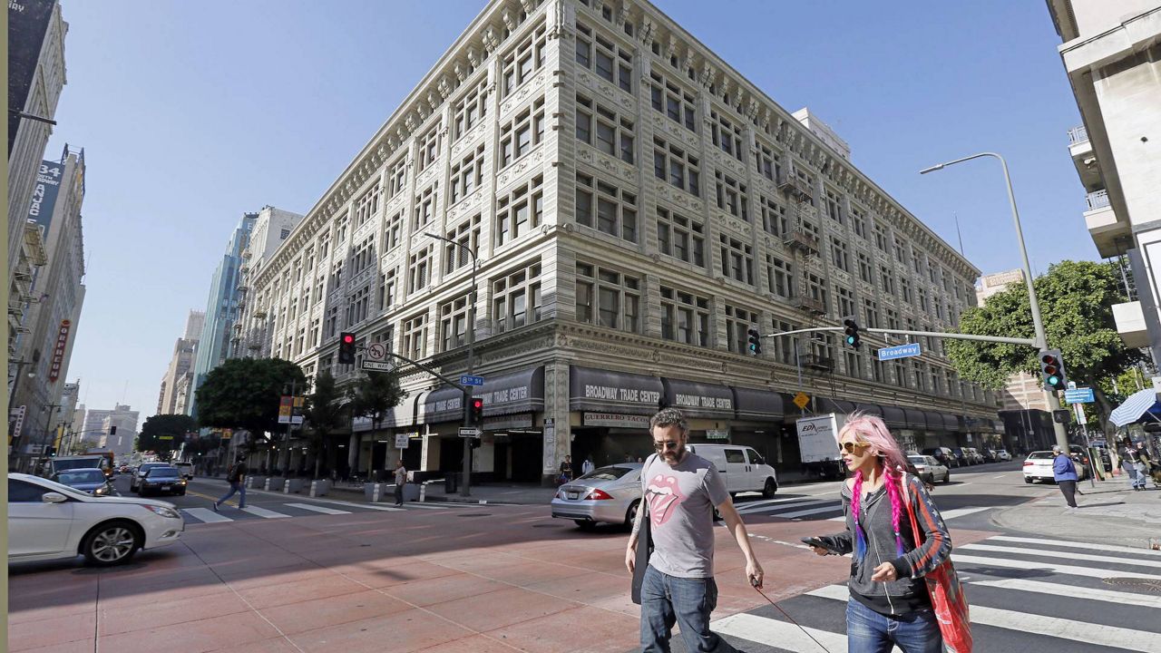 Pedestrians walk past the former May Co. department store in the Broadway corridor. (AP Photo/Nick Ut)