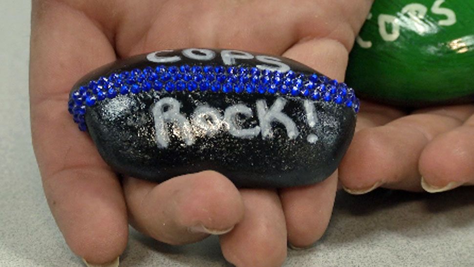 Makayla Kepler paints "Cops Rock" on rocks and decorates them before giving them to various law enforcement throughout Central Florida and the world. (Spectrum News 13)