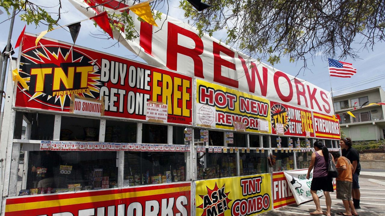 In this July 2, 2013, file photo, a family purchases fireworks at a TNT Fireworks stand in the City of Monterey Park, Calif. (AP Photo/Nick Ut, File)