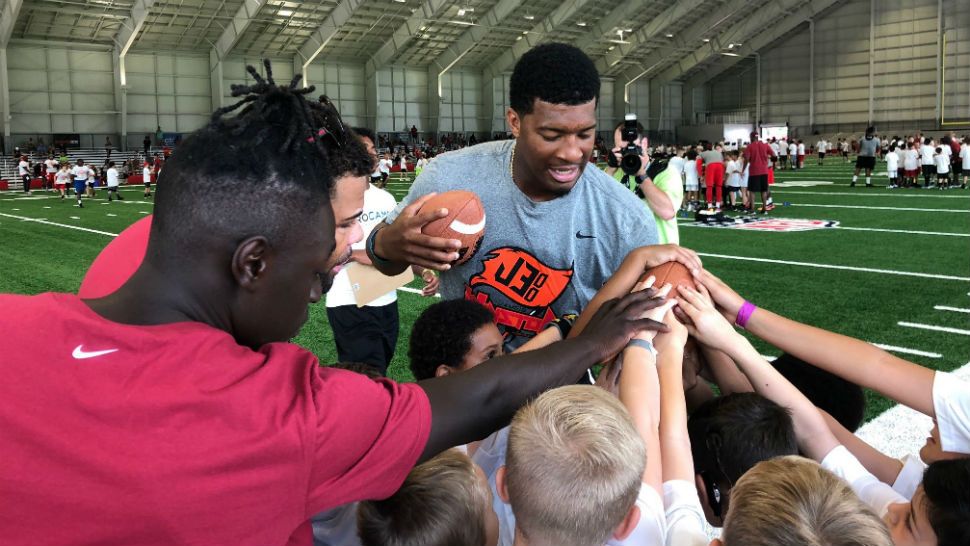 Bucs QB Jameis Winston interacts with several kids during the annual youth football camp. (Tim Wronka, staff)