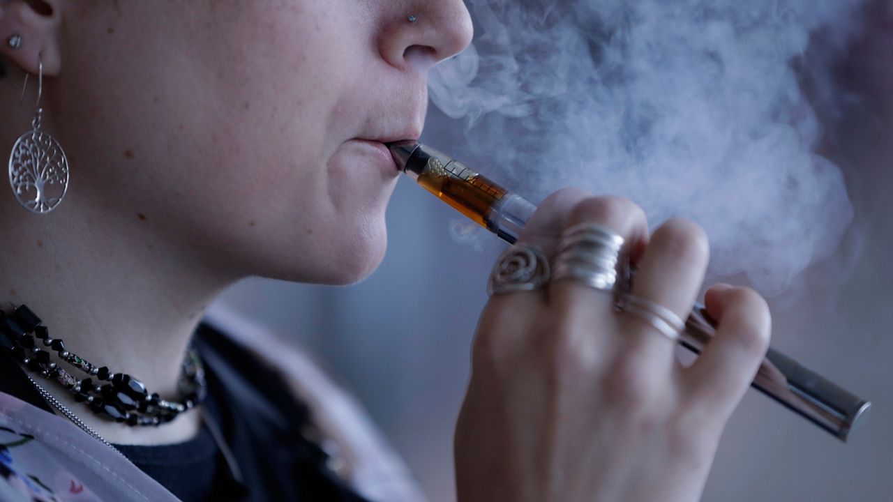 Close up of a woman exhaling vapor from an e-cigarette