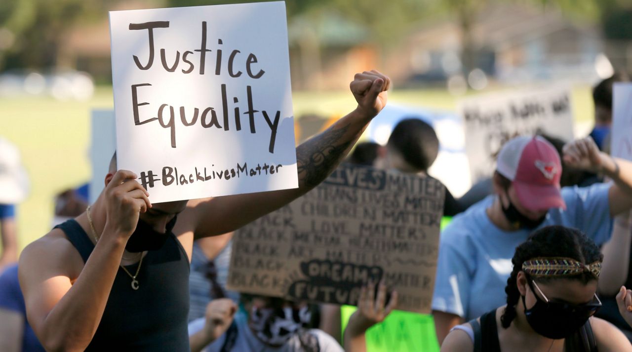 Demonstrators kneel, squat and sit in silence for over eight minutes as they peacefully protest at a neighborhood park in Richardson, Texas, Wednesday, June 3, 2020. Protests continued following the death of George Floyd, who died after being restrained by Minneapolis police officers on May 25. (AP Photo/Tony Gutierrez)