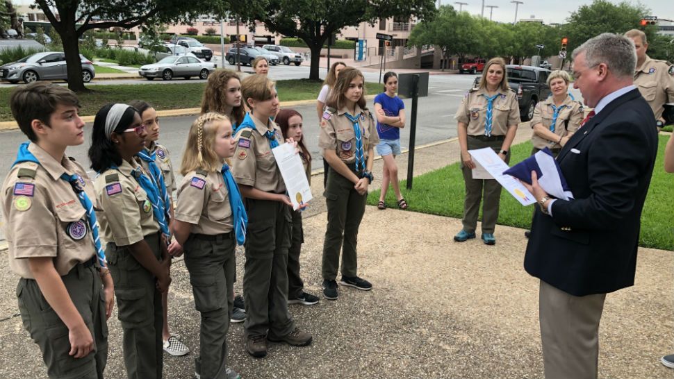 An all-girl troop of Scouts raised the flags at the Office of the Governor on the anniversary of the passage of the 19th amendment. (Spectrum News/Ed Keiner)