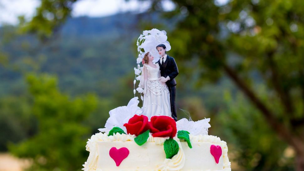 FILE - Bride and groom wedding cake topper. 