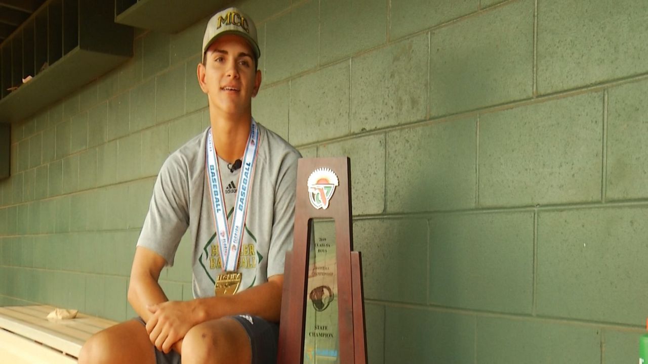 Zach Beolet poses with 5A State Championship trophy while talking to Despina Barton earlier in the week. 