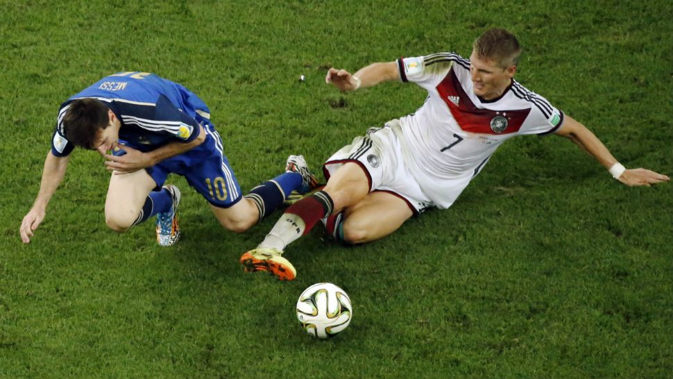 Germany's Bastian Schweinsteiger, right, tackles Argentina's Lionel Messi during the World Cup final soccer match between Germany and Argentina at the Maracana Stadium in Rio de Janeiro, Brazil, Sunday, July 13, 2014. Mario Goetze volleyed in the winning goal in extra time to give Germany its fourth World Cup title with a 1-0 victory over Argentina on Sunday. (AP Photo/Fabrizio Bensch, Pool)