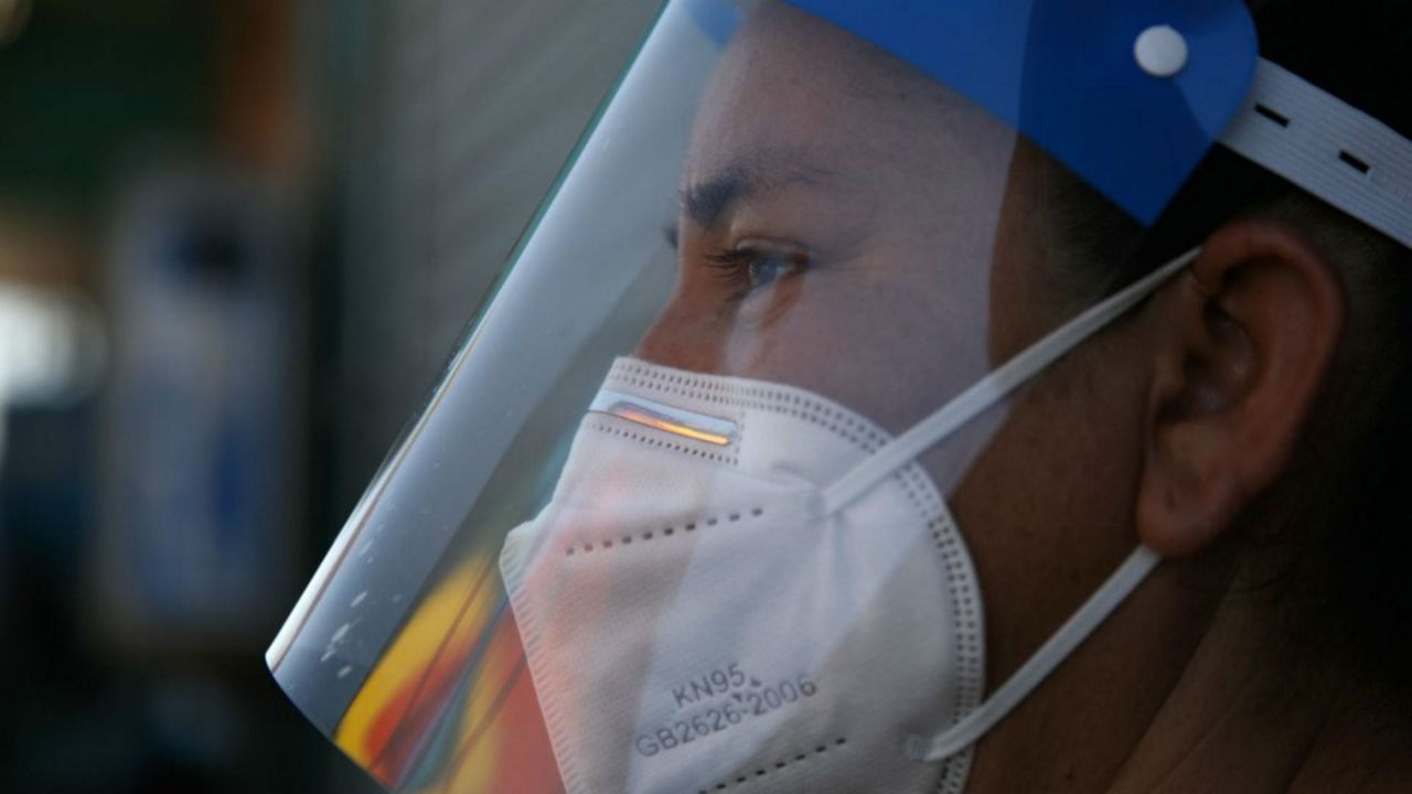 Street vendor Laticia Ortega wears a plastic shield over her mask during the coronavirus pandemic in the Vermont Square neighborhood of Los Angeles, Thursday, May 21, 2020. While most of California took another step forward to partly reopen in time for Memorial Day weekend, Los Angeles County didn't join the party because the number of coronavirus cases has grown at a pace that leaves it unable to meet even the new, relaxed state standards for allowing additional businesses and recreational activities. (AP Photo/Jae C. Hong)