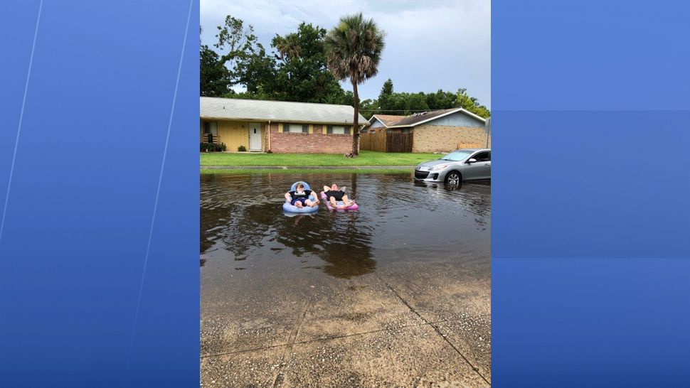 Residents are seen floating down their street in Port Orange at heavy rain flooded parts of the neighborhood. (Melissa Herlehy, viewer)