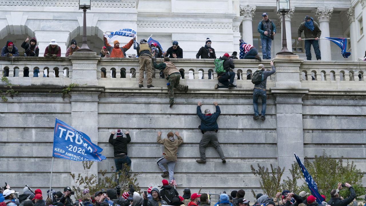 Supporters of President Donald Trump climb the west wall of the the U.S. Capitol in Washington. (AP Photo/Jose Luis Magana) 